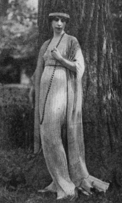 "Mrs. Condé Nast wearing one of the famous Fortuny tea gowns. This one has no tunic but is finely pleated, in the Fortuny manner, and falls in long lines, closely following the figure, to the floor. Observe the decorative value of the long string of beads.", c. 19171